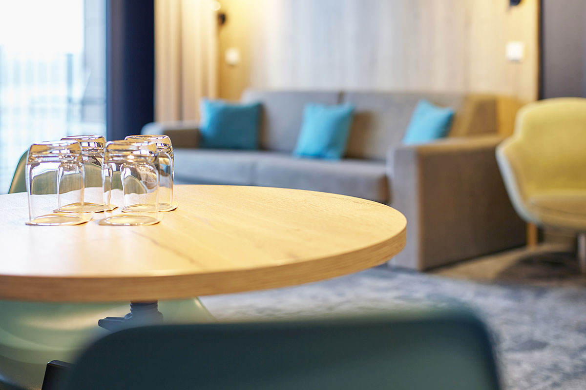 Wohnzimmer mit Couch, Sessel und kleinem Coffee table in der ancora Suite im arborea Marina Resort Neustadt.