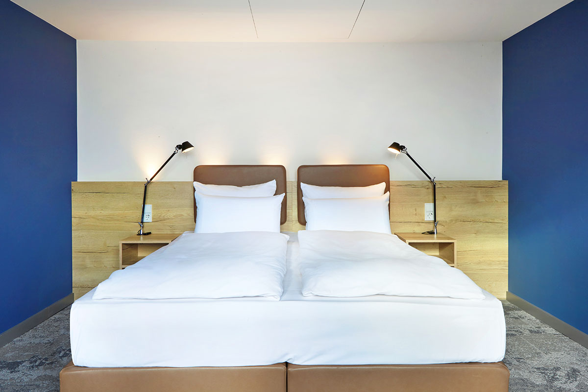 Ein gemütliches Doppelbett in der arborea Junior Suite im arborea Marina Resort Neustadt.
