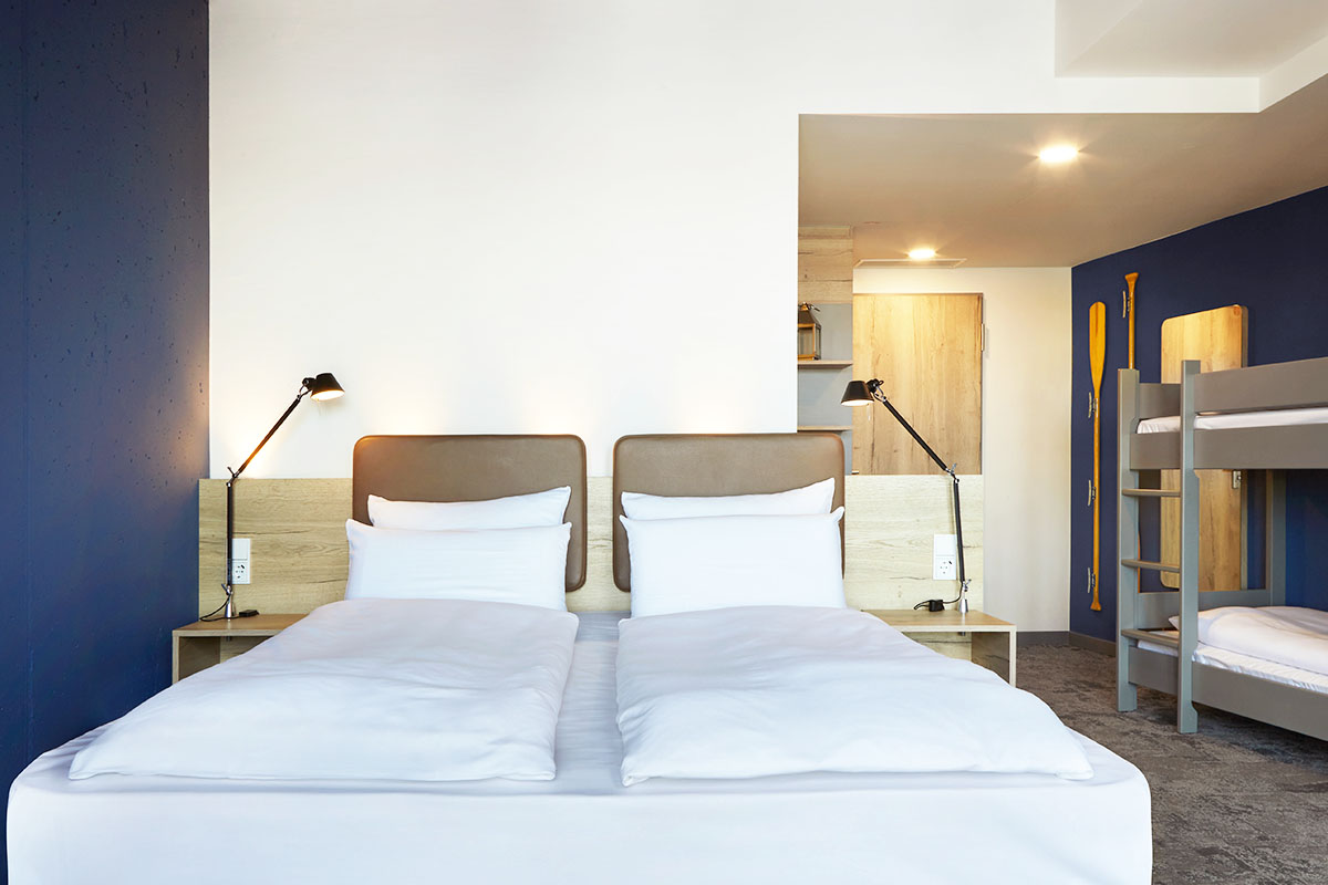 Kingsize Doppelbett und Etagenbett im Viererzimmer Auszeit im arborea Marina Resort Neustadt.