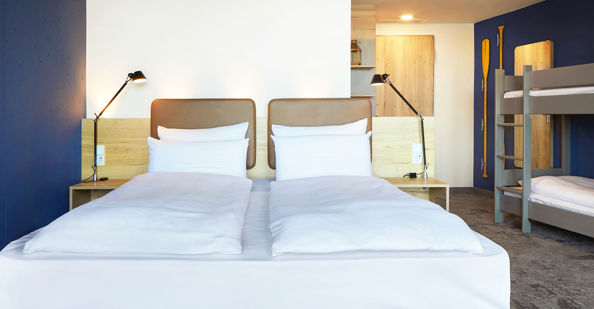 Kingsize Doppelbett und ein zusätzliches Etagenbett im Viererzimmer Auszeit im arborea Marina Resort Neustadt.
