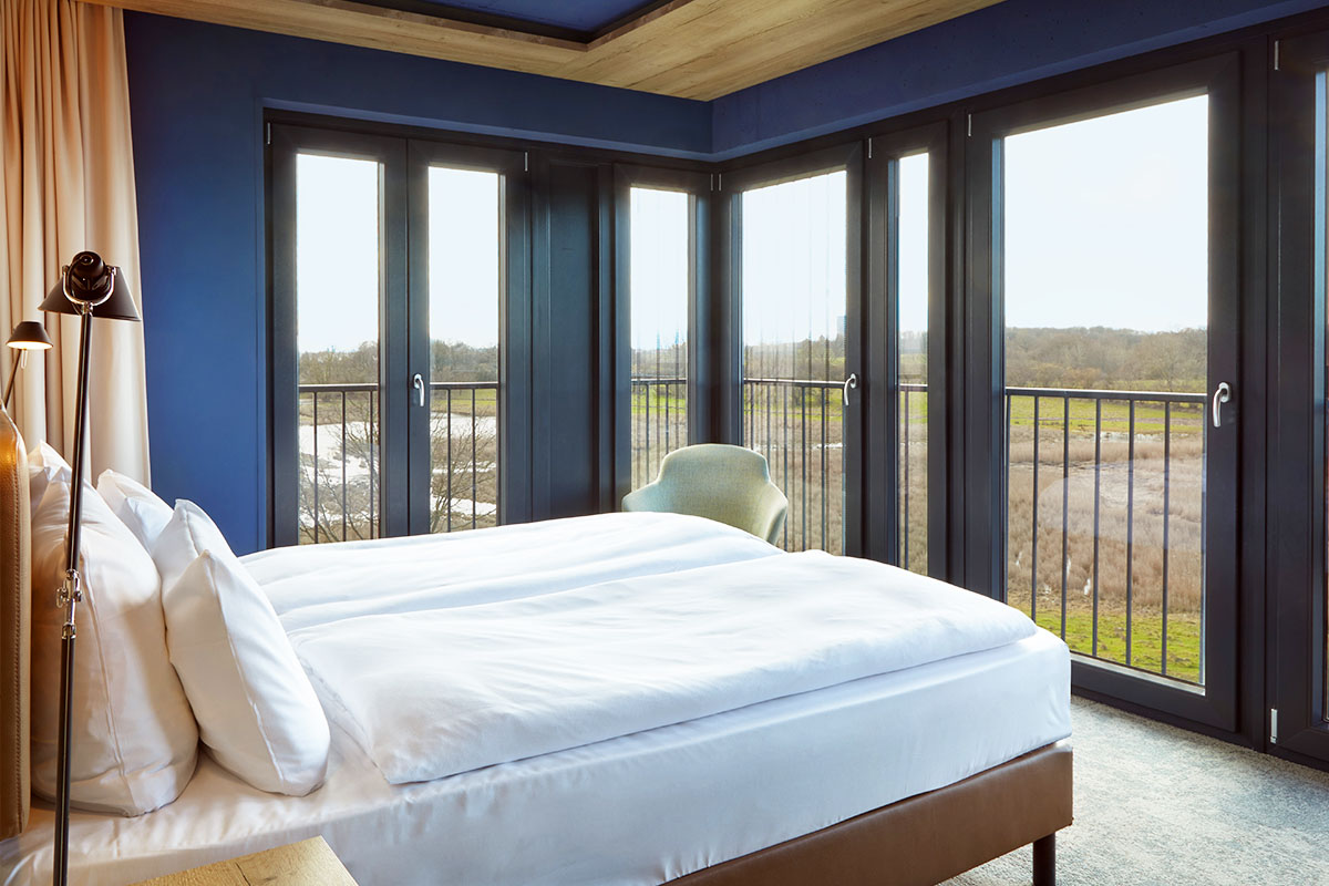 Kingsize Doppelbett mit Ausblick auf die Landseite im Doppelzimmer Landblick des arborea Marina Resort Neustadt.