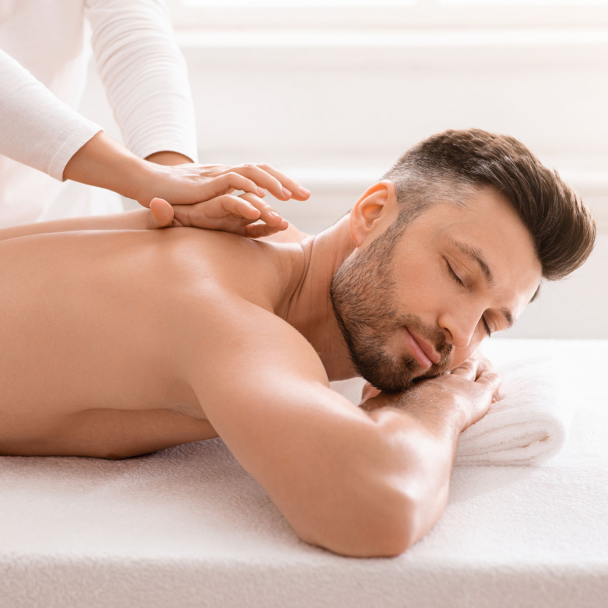Ein Mann genießt eine verwöhnende Massage im SPARADISE des arborea Marina Resort Neustadt.