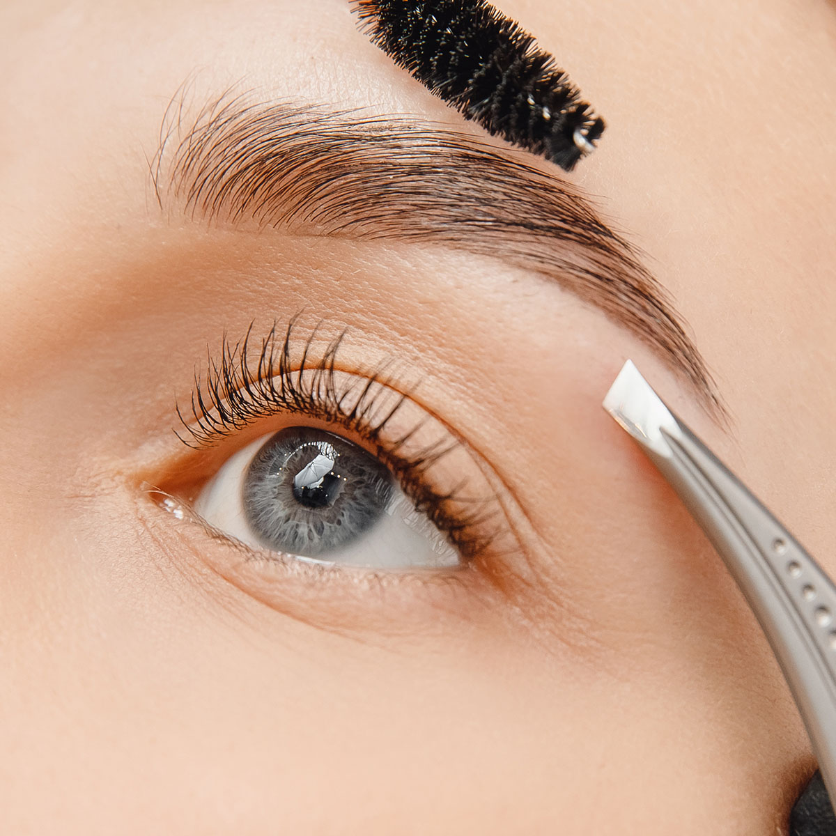 Die Augenbrauen einer Frau werden mit einer Pinzette und einem Augenbrauenkamm zurecht gezupft im SPARADISE des arborea Marina Resort Neustadt.